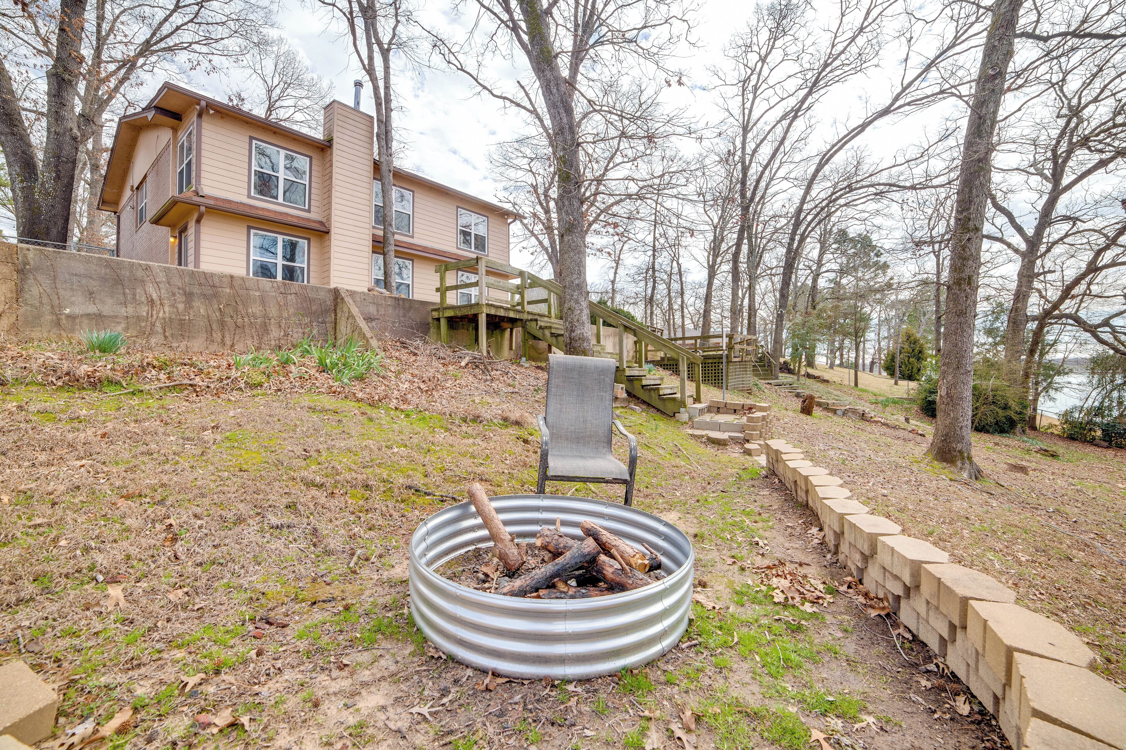 A two-story house with a deck and a fire pit in the yard.