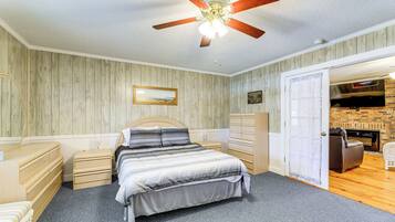 A bedroom with a bed, dresser, nightstands, and a ceiling fan.