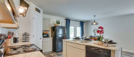 A modern kitchen with a built-in stove, a refrigerator, and a dishwasher.