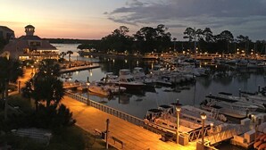 A marina with boats docked, a dock with a walkway, and a building with a tower. - Oceanfront beach villa in Palmetto Dunes (Hilton Head)