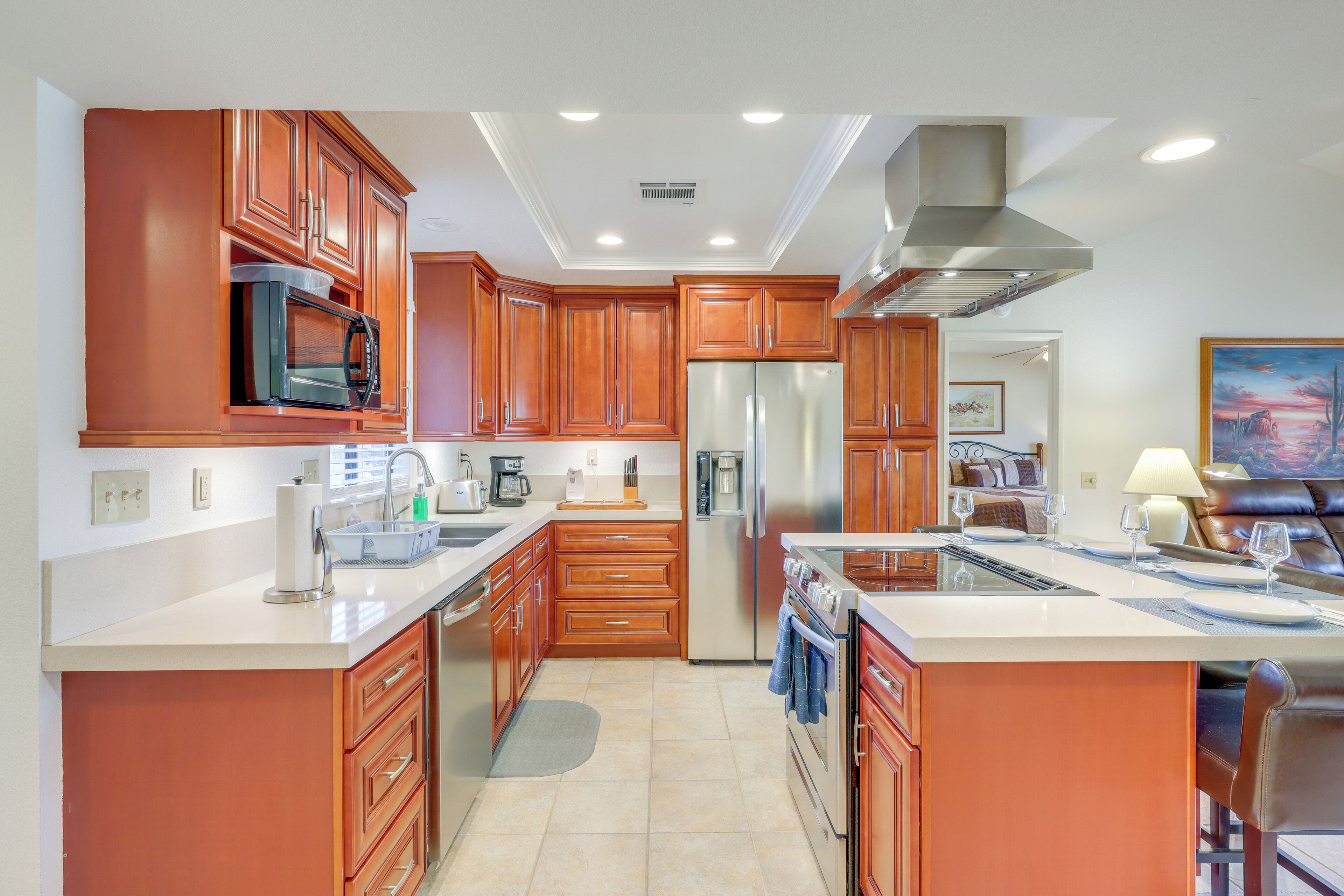 A spacious kitchen with wooden cabinets, stainless steel appliances, and a large island with seating.