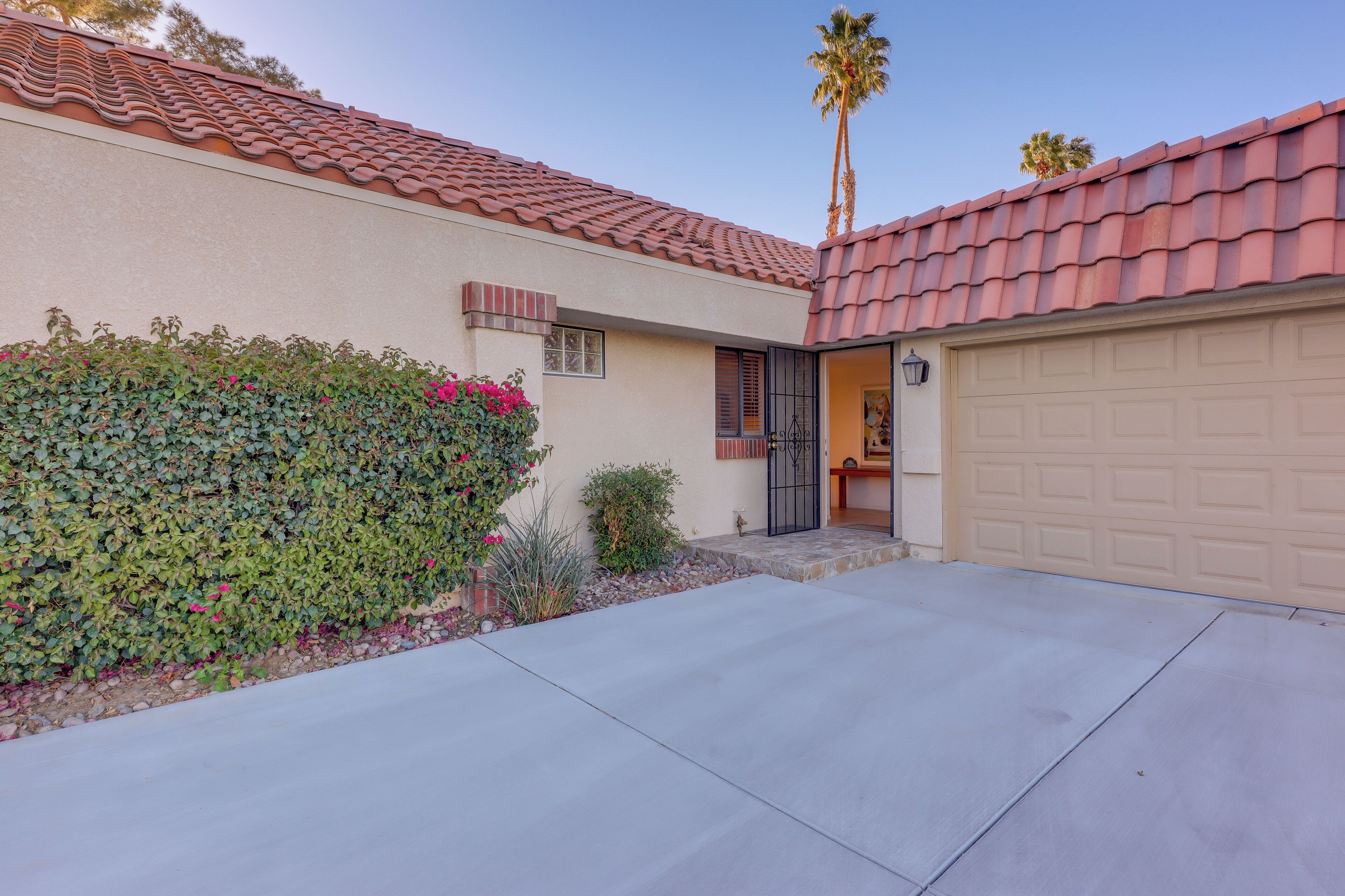 A residential house with a tiled roof, a garage, and a well-maintained garden.