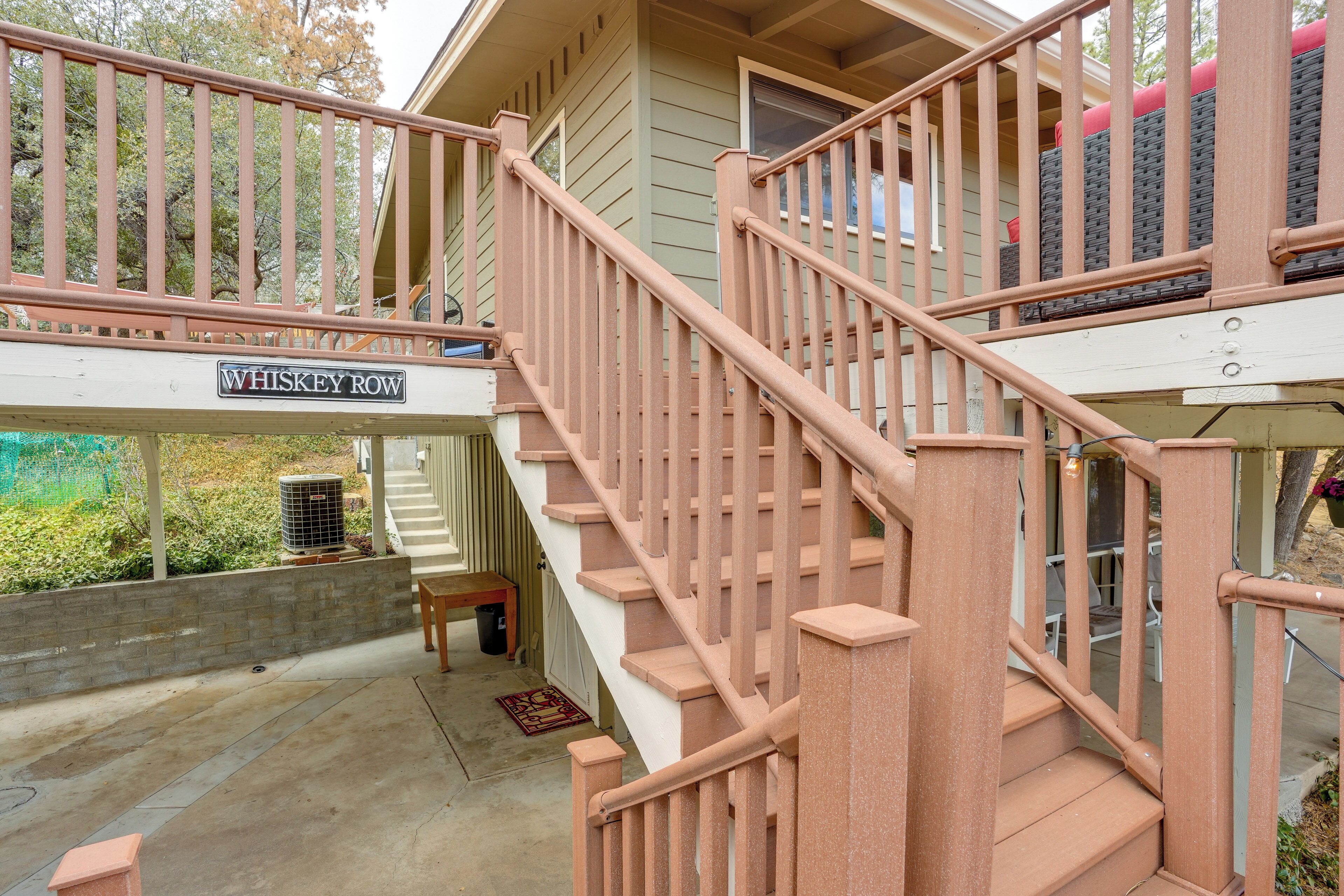 A staircase with a wooden handrail leading to a porch area.