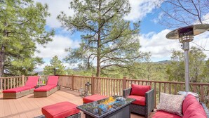 A deck with wicker furniture, red cushions, and a glass-top table with a fire feature. - Family Mountain Getaway, Retreat to the Cool Pine (Prescott)