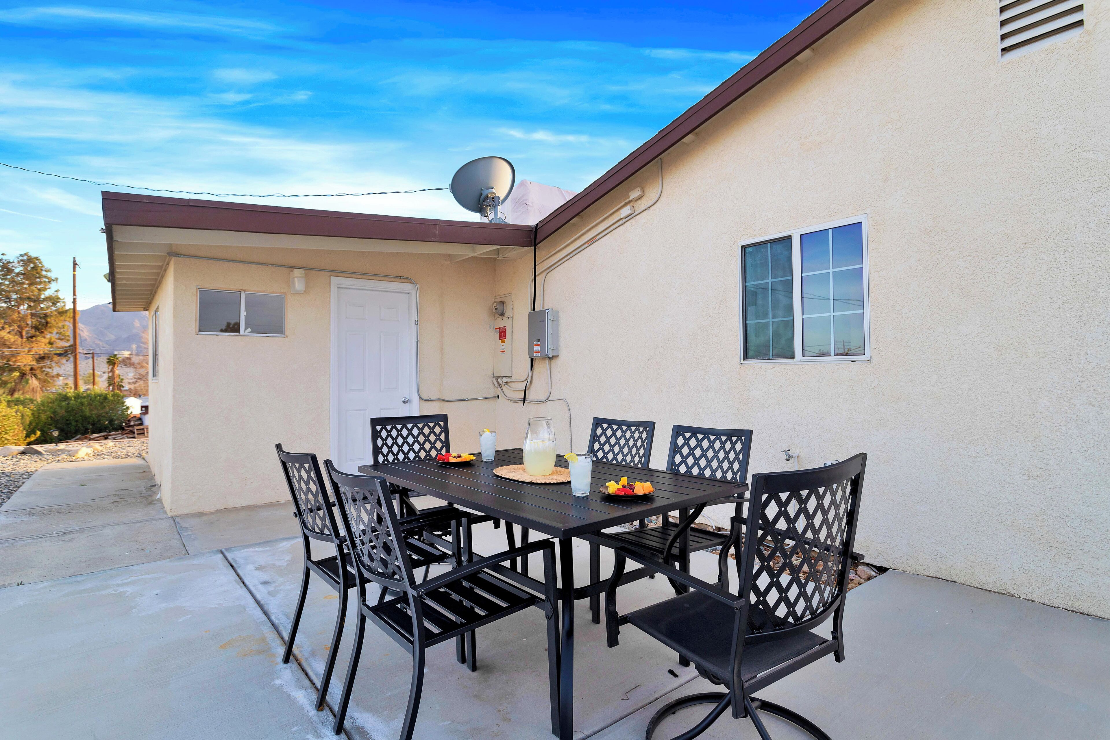 A patio with a table and chairs, a satellite dish, and a door.