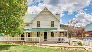 A two-story house with a green roof, white exterior, and a porch with white railings. - Historic 'mcbride House' in Garden Valley Mtns! (Garden Valley)