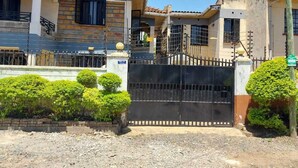 A gated residential area with a house featuring a tiled roof, a balcony, and a gated entrance. - Standard Gardens Milimani Kisumu (Kisumu)