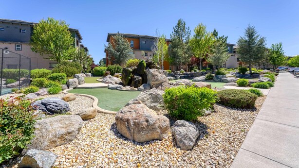 Un jardín ajardinado con rocas, arbustos y un sendero.