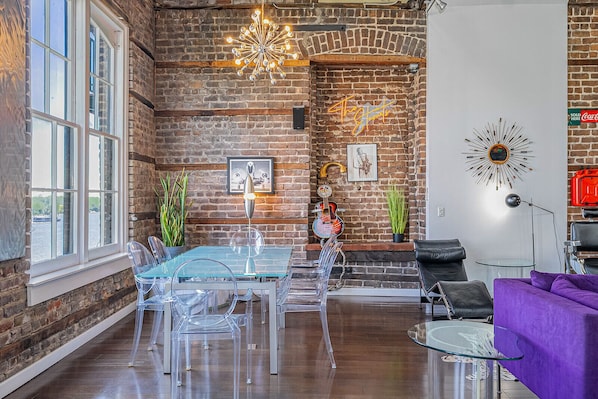 Relax in this stylish living space with a comfortable sofa, leather chair, and dining table.