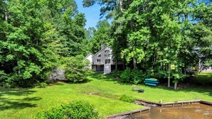 A house surrounded by lush greenery and a small pond. - Tide & Timber | Community Swiming Pool | Pet-Friendly (Fee) (Littleton)
