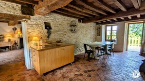 A rustic kitchen with a wooden counter, stone walls, and a hexagonal tile floor. - Gîte Le Belvédère du Lac between lakes and castles of the Dukes of Burgundy (Civry-en-Montagne)