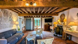 A rustic living room with exposed wooden beams, a fireplace, and a cozy seating area. - Gîte Le Belvédère du Lac between lakes and castles of the Dukes of Burgundy (Civry-en-Montagne)