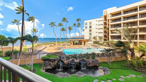 A resort with a pool, palm trees, and a view of the ocean. - Gorgeous Oceanfront Remodel I Sugar Beach 210 (Kihei)