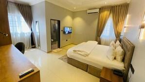 Une chambre d’hôtel équipée d’un lit, d’un bureau, d’une télévision et d’un appareil de climatisation.