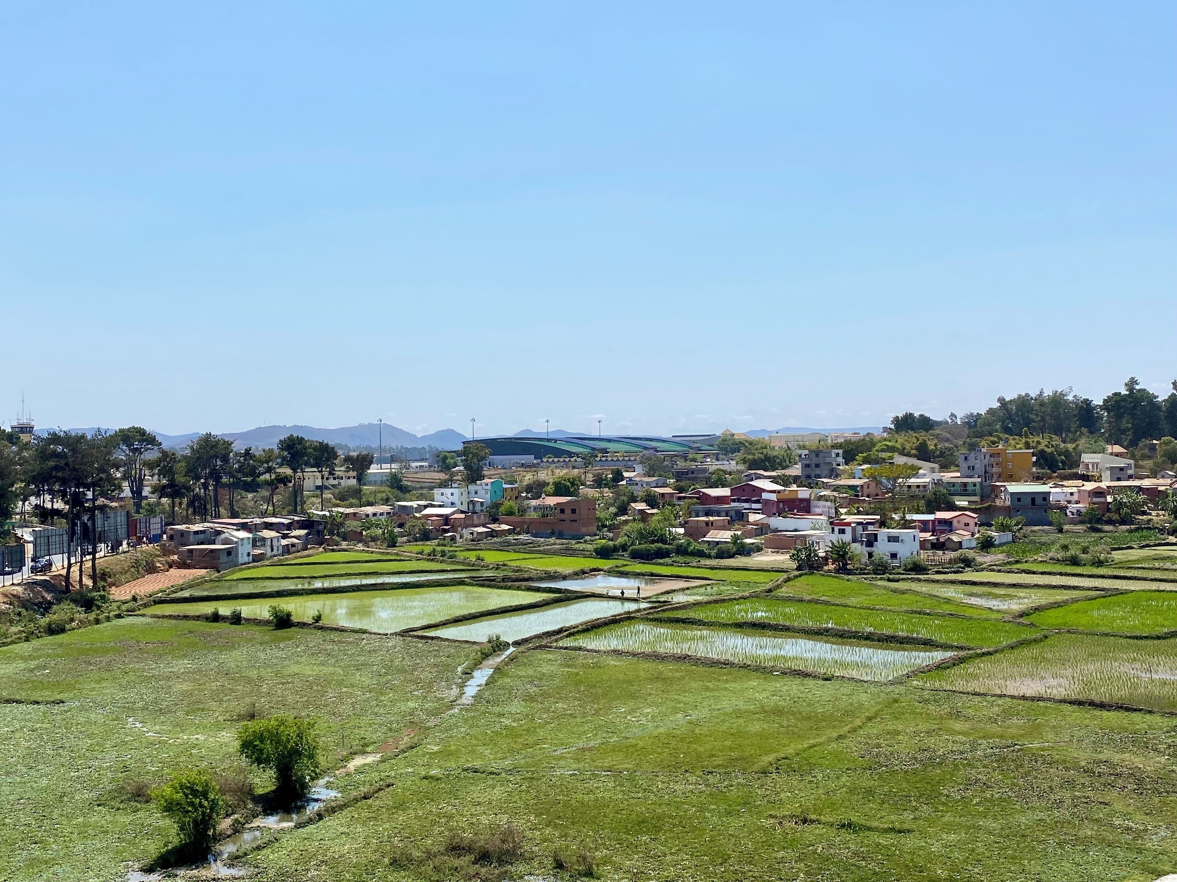 A rural landscape with terraced fields and scattered buildings.