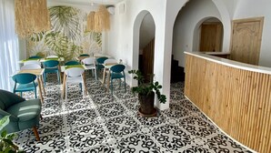 A modern hotel lobby with a reception desk, seating area with chairs and tables, and a patterned floor. - Hôtel Escale (Antananarivo)