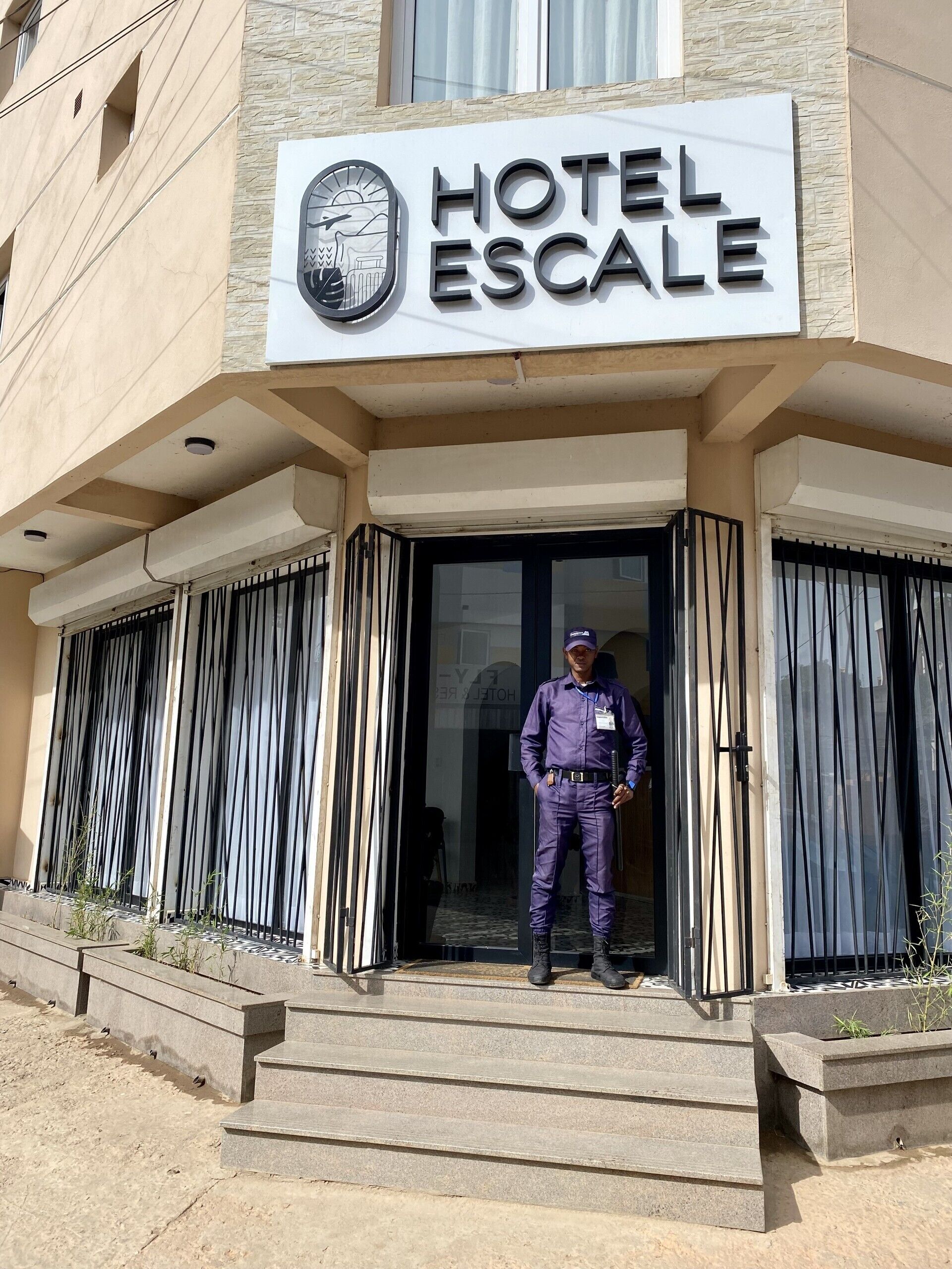 A hotel entrance with a sign reading "HOTEL ESCALA".