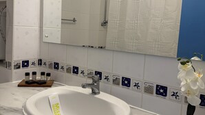 A bathroom with a white sink, a mirror, and a shower. - Briza Boutique Mamaia (Constanta)