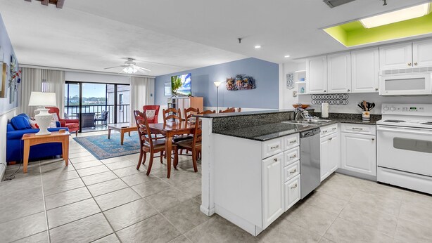 A modern kitchen with white cabinets, a granite countertop, and a built-in oven. - Pelican's Perch - Expansive Condo with Water Views, Pool-Across from Beach (Indian Shores)
