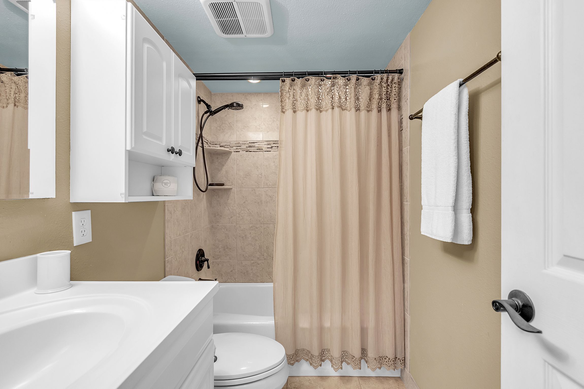 Un baño con bañera, inodoro y cortina de ducha.