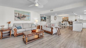 Ein modernes Wohnzimmer mit Sofa, Couchtisch und einem Essbereich mit Stühlen und Tisch.