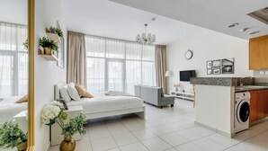 Un salon moderne avec un canapé, un téléviseur et un lave-linge en arrière-plan.