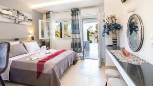 Ein Hotelzimmer mit Bett, Schreibtisch, Stuhl, Spiegel und Blick ins Freie.