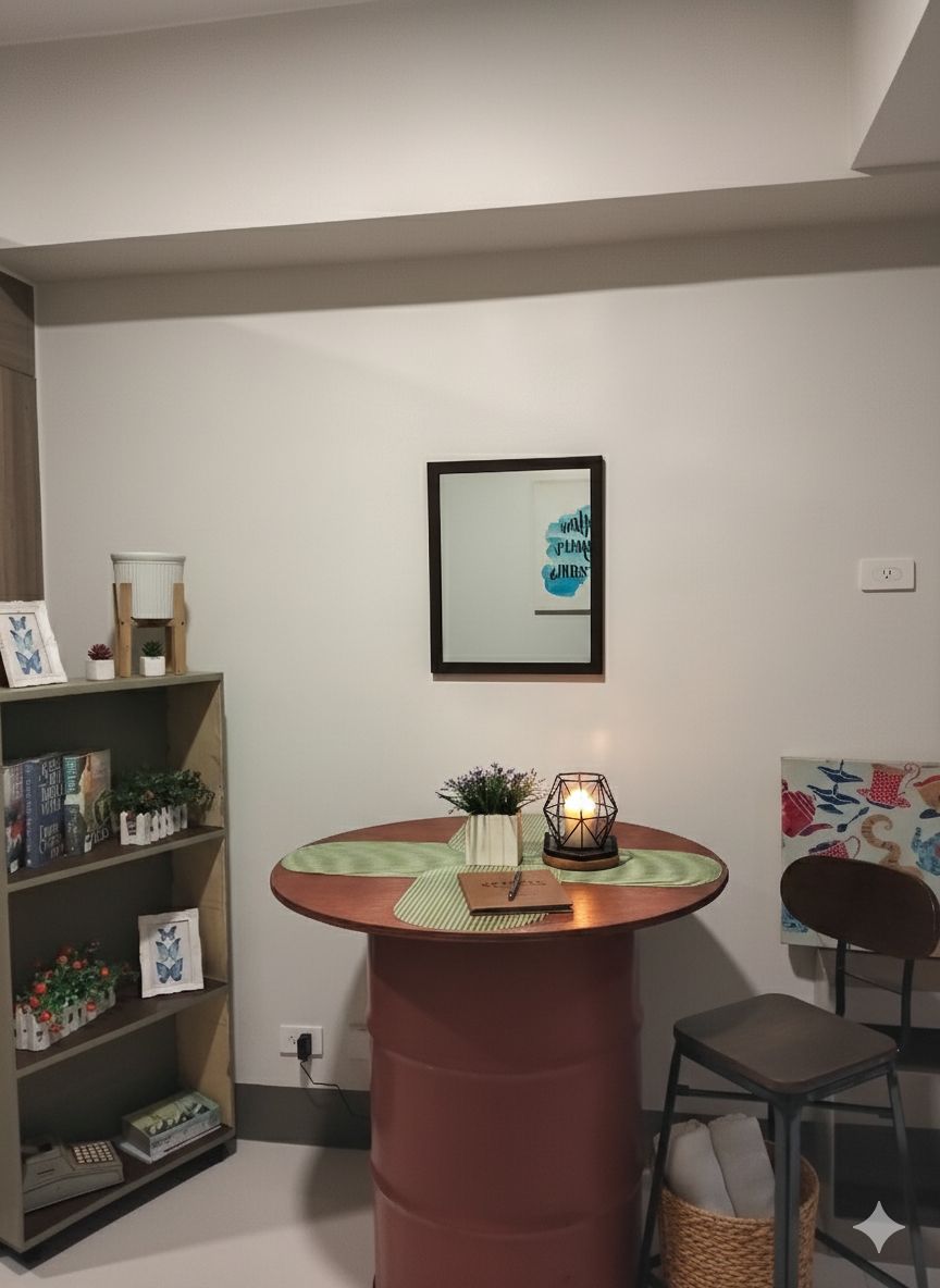 A room with a round wooden table, a bookshelf, a framed picture, and a chair.