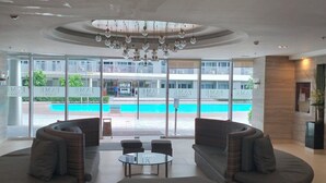 Un vestíbulo amplio con vista a la piscina, muebles modernos y un candelabro.