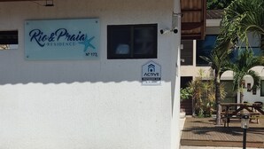 Een klein gebouw met een bordje met de tekst 'Rio & Praia Residence' en een beveiligingsbadge met 'ACTIVE'.