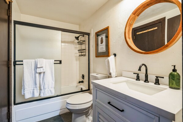 Un baño con ducha, inodoro, lavabo y tocador.