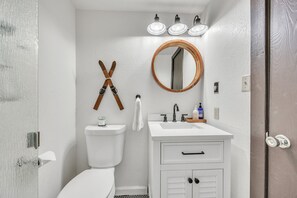A bathroom with a toilet, sink, vanity, and a mirror. - Alpine Retreat In The Heart Of Incline Village 2 Bedroom Condo (Incline Village)