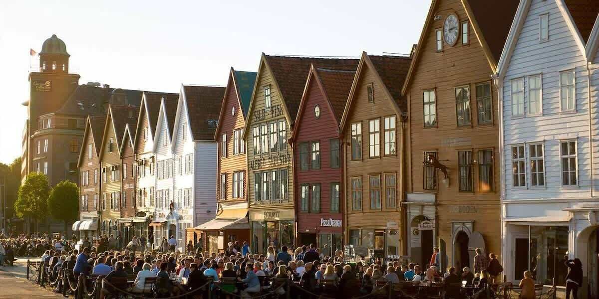 A row of traditional European-style buildings with a crowd of people in front.