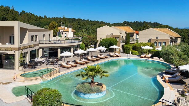 A resort with a large swimming pool, sun loungers, and a restaurant. - Ohana Hotel (Kassandra)