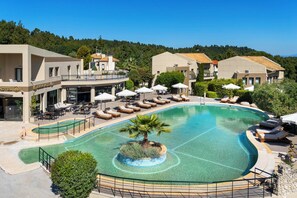 Um resort com uma grande piscina, espreguiçadeiras e um restaurante.