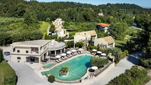 An aerial view of a resort with a swimming pool, multiple buildings, and lush greenery. - Ohana Hotel (Kassandra)