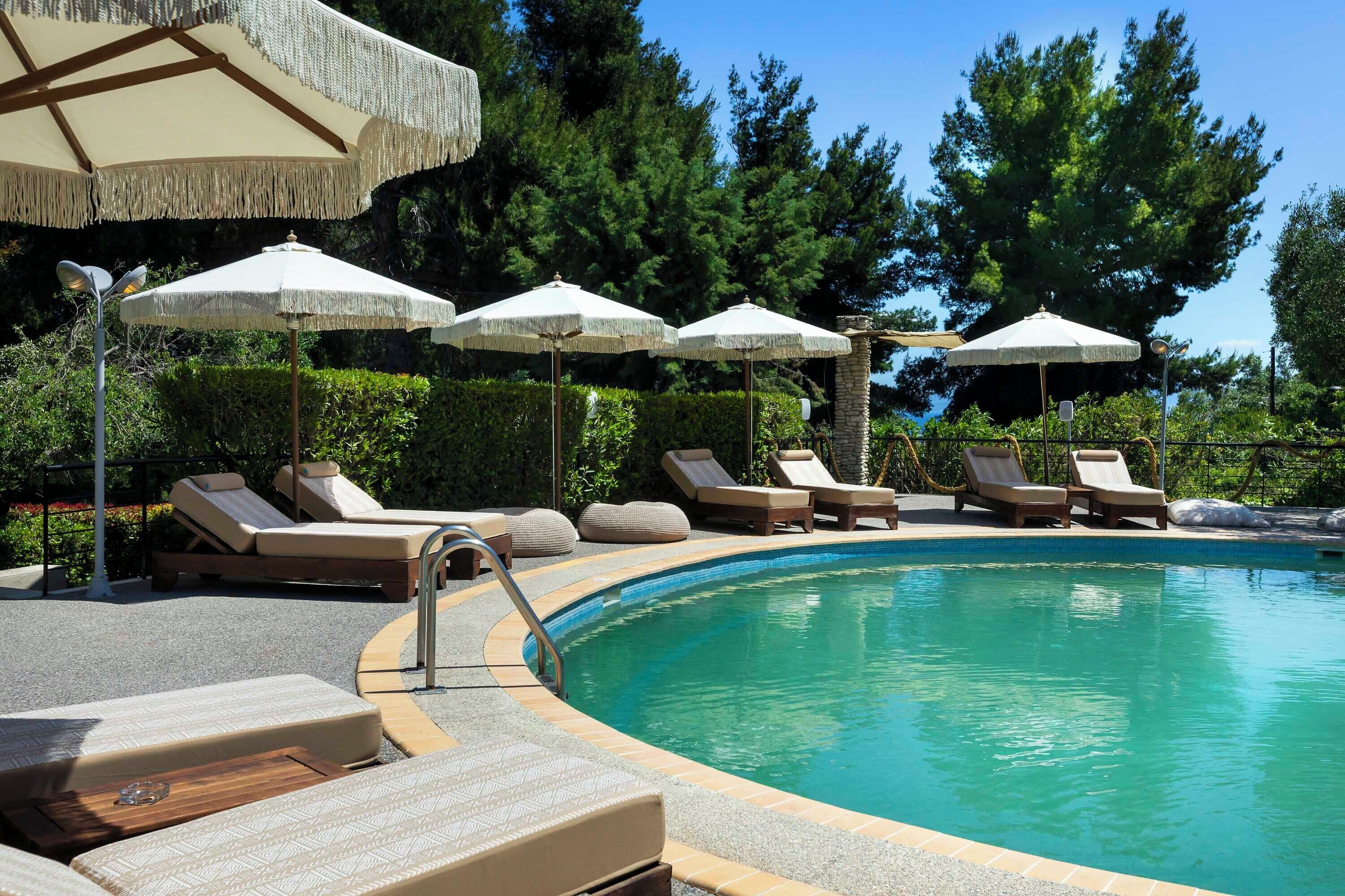 Ein Poolbereich mit Liegestühlen und Sonnenschirmen.