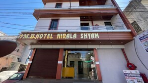 Ein mehrgeschossiges Hotel mit moderner Fassade, mit einem gut sichtbaren Schild für "M.B. HOTEL NIRALA SHYAM".