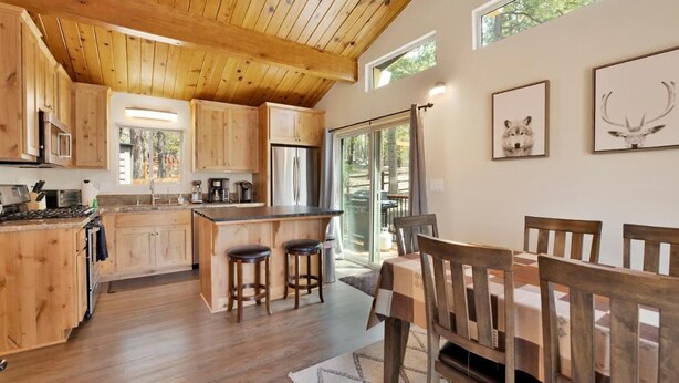 A wooden interior with a kitchen, dining area, and large windows.