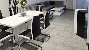Un salon moderne comprenant un coin repas, un canapé, une table basse et une lampe.