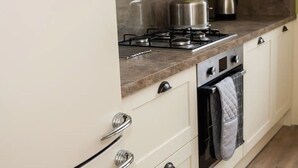 A kitchen with a gas stove, oven, and a kettle on the countertop. - Location! Location! Location! A Golf Lover’s Dream (St Andrews)