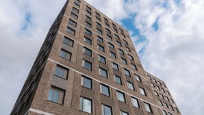 A tall, modern brick building with multiple windows and balconies, viewed from a low angle. - Student Only Old Kent Road (London)