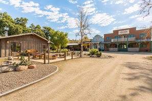 A Western-themed plaza with rustic wooden buildings, a dirt road, and a wooden fence. - Amazing Reviews - 10 Beds, 5 Br, Saloon,Jail,Spa! (Temecula)