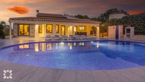 A luxurious villa with a swimming pool, outdoor seating, and a well-lit entrance. - Villa AVETA by Abahana Villas (Moraira)