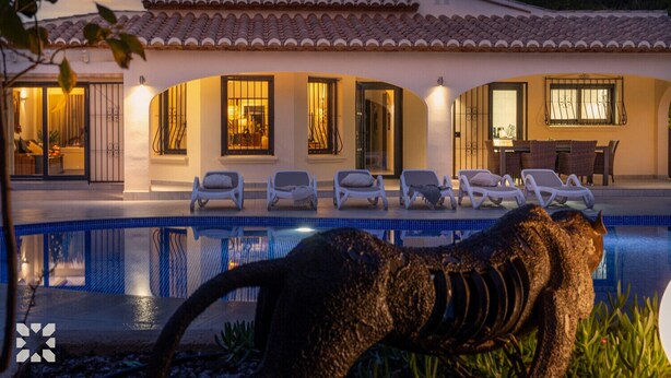 A poolside area with lounge chairs and a large sculpture of a dinosaur. - Villa AVETA by Abahana Villas (Moraira)
