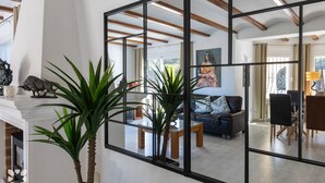 A modern living room with a large mirror, a sofa, and a dining area. - Villa AVETA by Abahana Villas (Moraira)