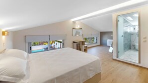 A modern bedroom with a large bed, a desk, and a view of an outdoor swimming pool. - Villa Oasis in Nikiana - Sleep 6 - Pool - Hot Tub (Lefkada)