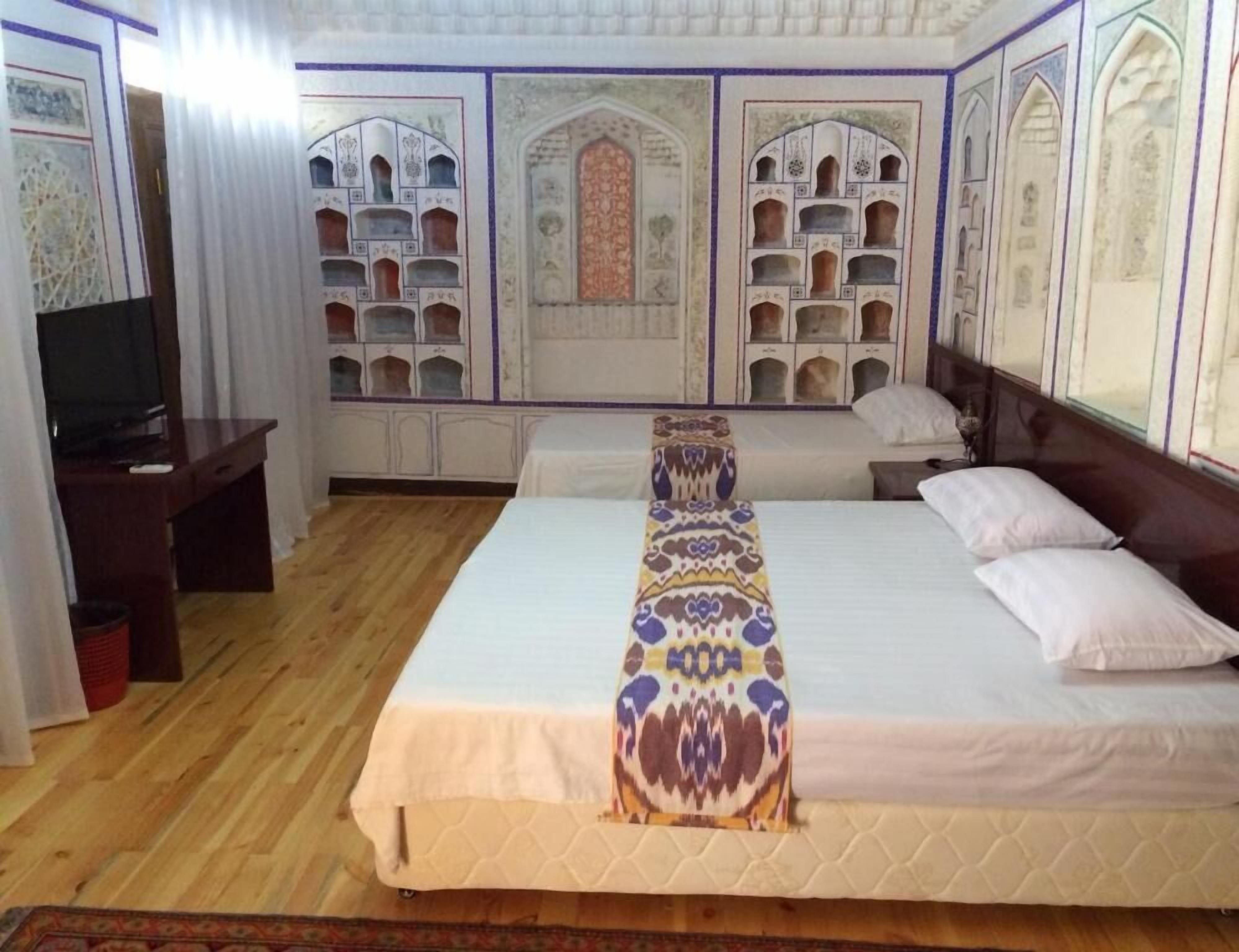 Een slaapkamer met een groot bed, een televisie en decoratieve wandpanelen.