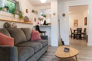 Un salon moderne comprenant un canapé, une table basse et un coin repas avec des chaises et une table.