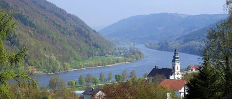 A river valley with a church and residential buildings.